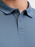 Blauw poloshirt met knoopsluiting en geribbelde textuur.