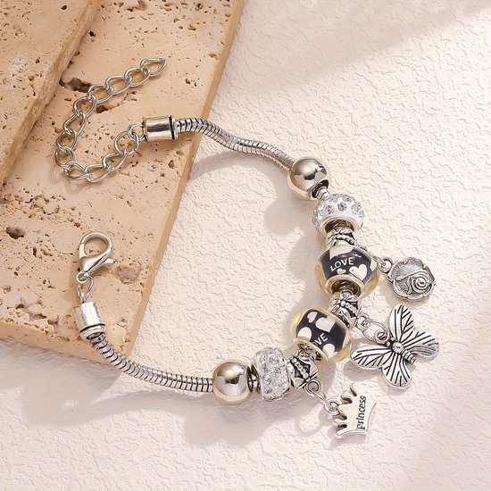 Zilverkleurige bedelarmband met 'Princess'-kroon, vlinder, roos en kraaltjes met 'LOVE'-tekst.