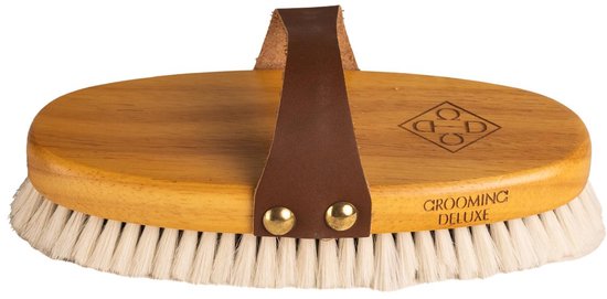 Ovalen borstel met houten handvat, bruine leren band en witte haren. Tekst 'GROOMING DELUXE' op de borstel.