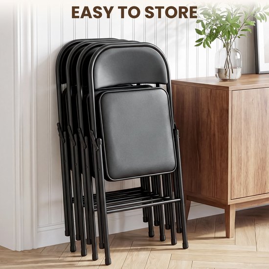 Een stapel van vijf zwarte inklapbare stoelen, makkelijk op te bergen tegen een muur.