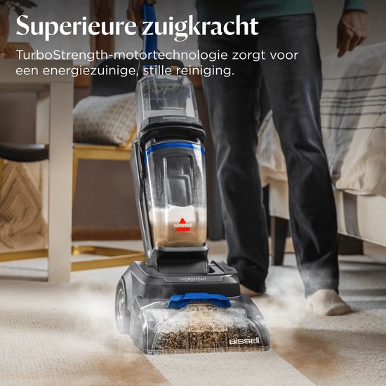 Een zwarte BISSELL PowerWash HydroSteam tapijtreiniger met grote tanks, die stoom gebruikt op een vloerkleed.