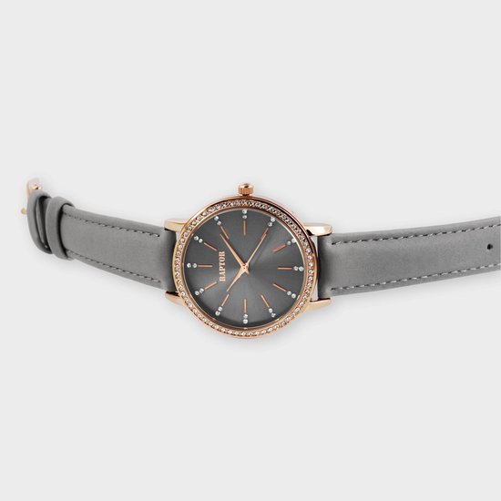 Raptor horloge met donkergrijze wijzerplaat, goudkleurige kast met steentjes en grijze leren band.