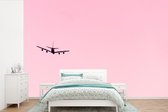 Behang - Fotobehang Stijgend vliegtuig in een roze lucht - Breedte 450 cm x hoogte 300 cm