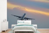 Behang - Fotobehang Vliegtuig dat richting de zonsondergang vliegt - Breedte 525 cm x hoogte 350 cm