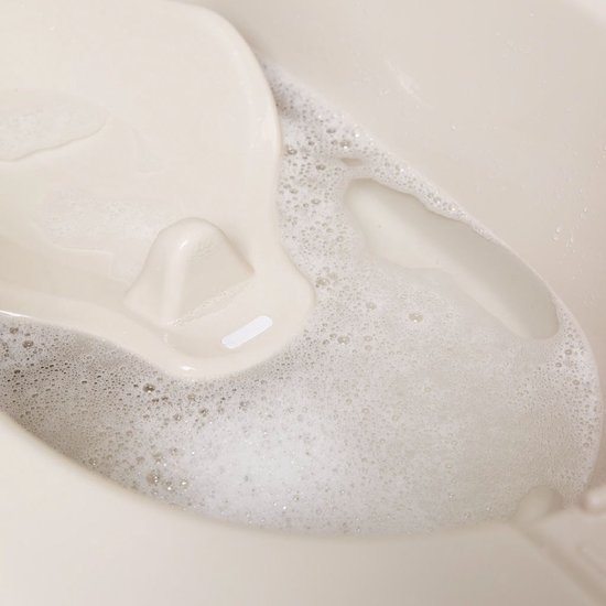 Beige badzitje met schuim in het water.