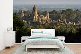 Behang - Fotobehang Angkor Wat tussen de bomen - Breedte 385 cm x hoogte 240 cm