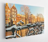 Canvas schilderij - Snow covered bikes in front of a canal in Amsterdam in winter  -     359789918 - 80*60 Horizontal