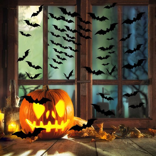 Fenêtre avec citrouille d'Halloween illuminée et de nombreux autocollants chauve-souris noirs s'envolant à l'extérieur.