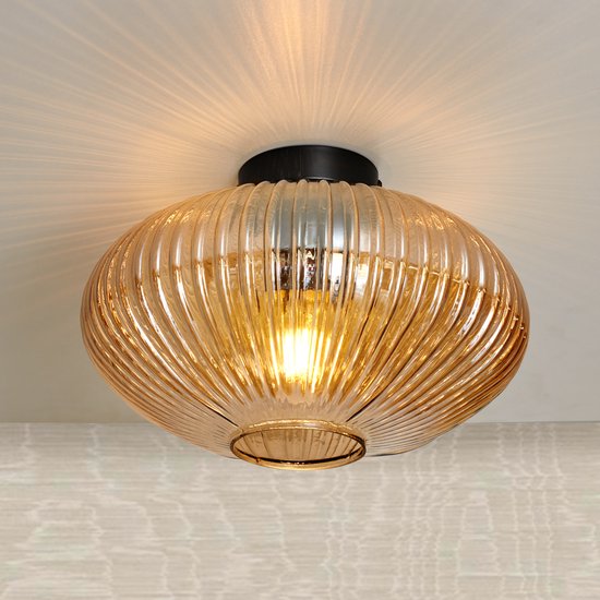 Amberkleurige plafondlamp van ribbelglas met zwarte fitting, verlicht.