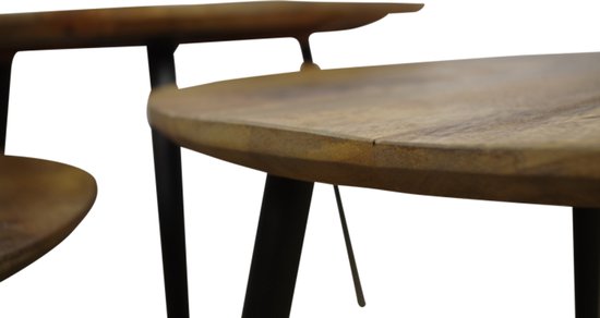 Close-up van twee ronde mangohouten salontafels met zwarte poten.