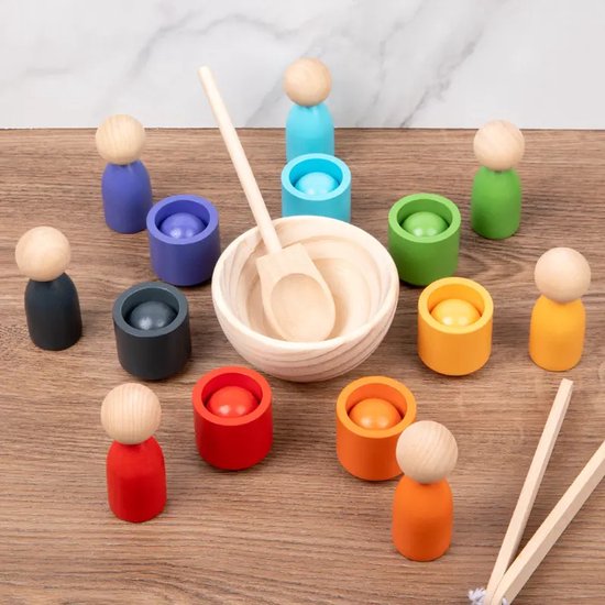 Houten poppetjes in diverse kleuren, omringend een houten kom met lepel.