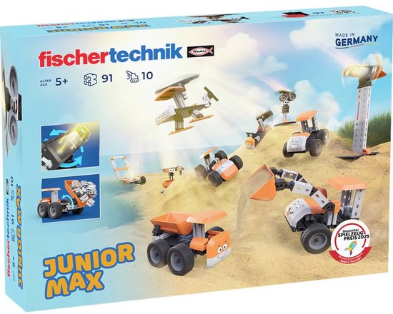 Doos van de fischertechnik Junior Max bouwset met afbeeldingen van verschillende oranje en grijze voertuigen op zand.