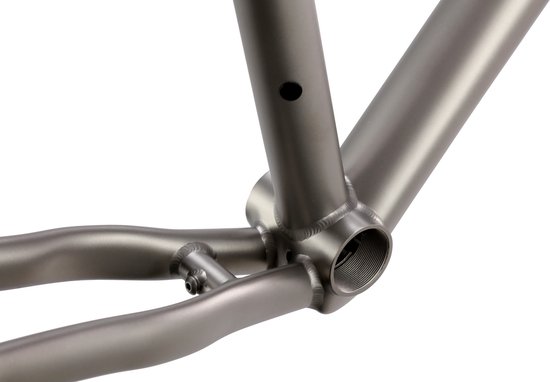 Detail van de trapas en achterbrug van een zilverkleurig titanium fietsframe.