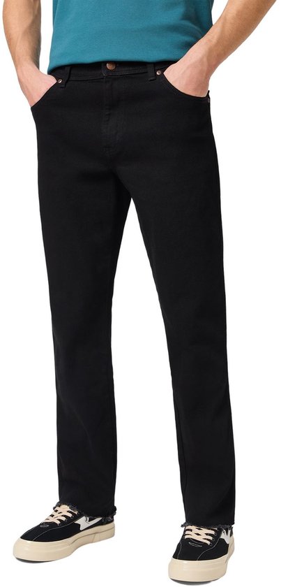 Man in zwarte regular/straight fit jeans en blauwe polo.