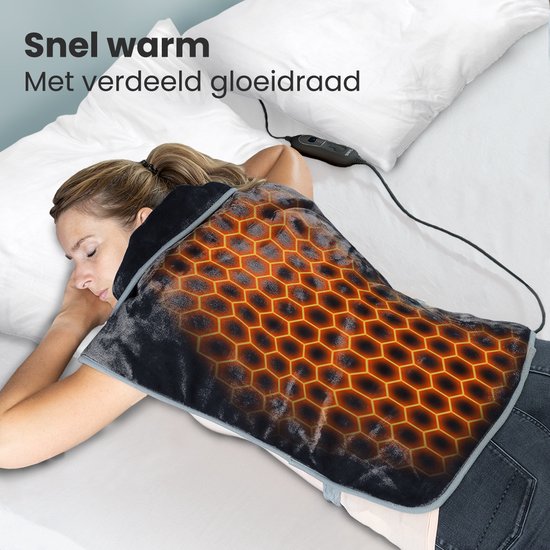Vrouw met gesloten ogen, slapend op een bed met de zwarte verwarmde schoudercape om haar nek en schouders. Goudkleurig honingraatpatroon toont verwarming.