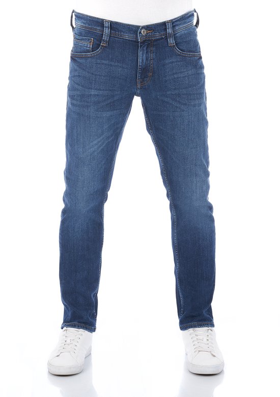 Vooraanzicht van een blauwe Mustang jeans met tapered fit, gecombineerd met witte sneakers.