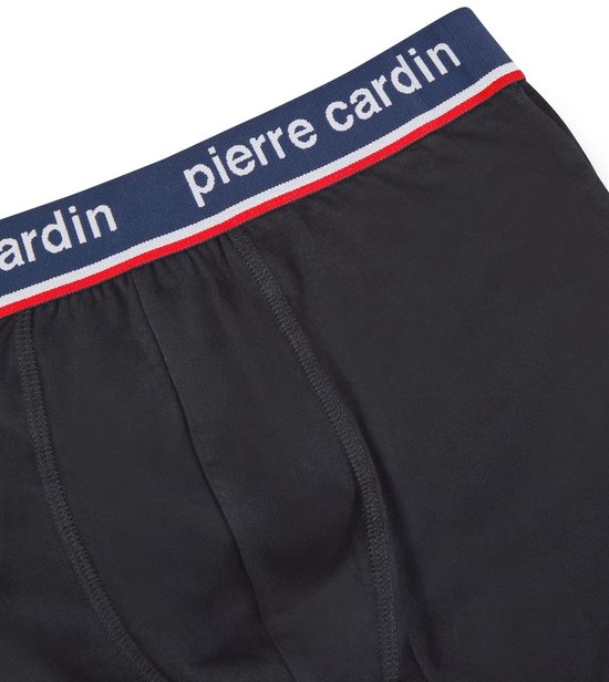 Detail van de donkerblauwe tailleband met witte en rode strepen en "pierre cardin" logo op zwarte boxershorts.