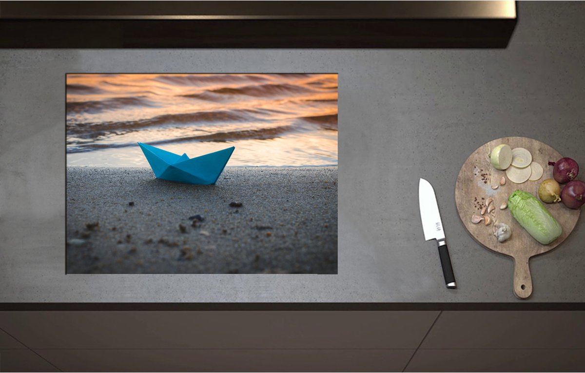Inductieplaat Beschermer - Blauwe Papieren Origami Bootje Aangespoeld op het Strand tijdens Opkomende Zon - 70x52 cm - 2 mm Dik - Inductie Beschermer - Bescherming Inductiekookplaat - Kookplaat Beschermer van Wit Vinyl