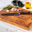 Koksmes met damascus print en donkerhouten handvat op een houten snijplank, met knoflook en dille.