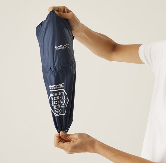 Handen vouwen een donkerblauwe dames regenjas op, metopdruk 'WOMEN'S PACK-IT JACKET'.