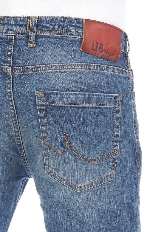 Close-up van de achterkant van een blauwe jeans met een bruin LTB logo patch.