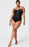 Mannequin vu de face, debout, portant une culotte taille haute noire avec un dos string.