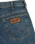 Detail van de achterzak van een spijkerbroek met Wrangler-label en W-stiksel.
