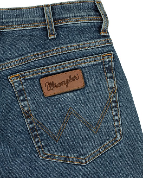 Detail van de achterzak van een spijkerbroek met Wrangler-label en W-stiksel.