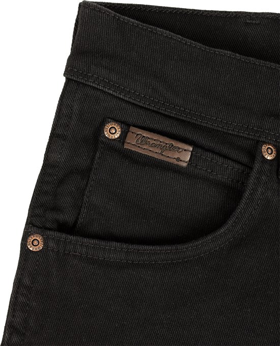 Zwarte Wrangler jeans met bruin logo label en koperen knopen.