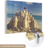 MuchoWow® Glasschilderij 60x40 cm - Schilderij acrylglas - Zandkasteel op het strand - Foto op glas - Schilderijen
