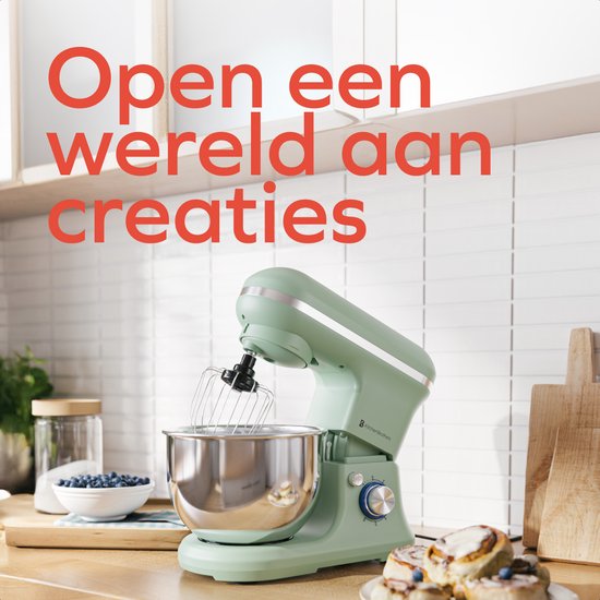 Pastelgroene keukenmachine in een keuken met een pot bosbessen en gebakken broodjes.