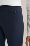 Close-up van donkerblauwe legging met een klein wit sterlogo op de linkerheup.