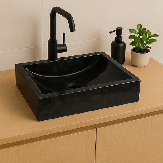 Mise en scène de salle de bain moderne avec lavabo rectangulaire en marbre noir, robinetterie noire et distributeur de savon.