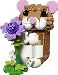 Hamster LEGO marron aux oreilles roses, tenant une fleur violette.