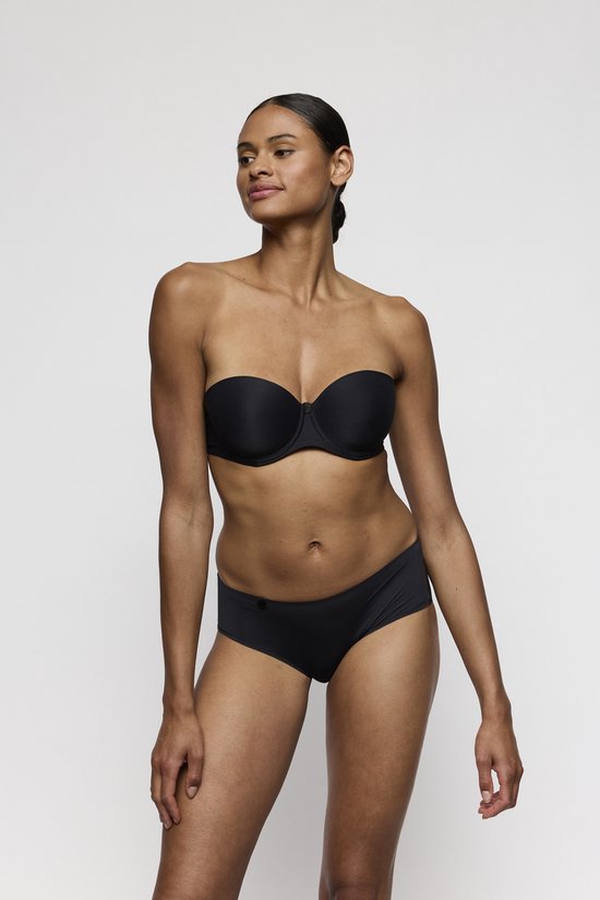 Model in zwart strapless lingerieset met de cup van de bh zichtbaar.