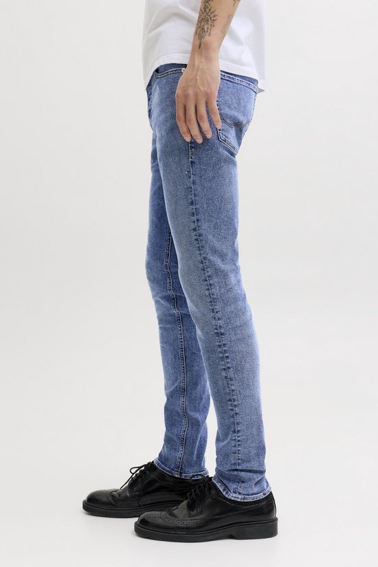Blauwe slim fit jeans met lichte wassing, gedragen door een man.