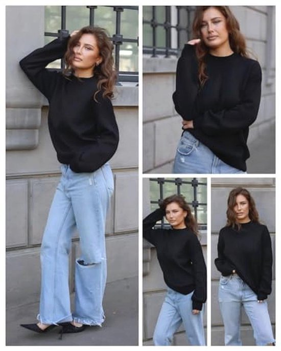 Model draagt een zwarte trui met ronde hals en wijd uitlopende jeans met gescheurde knieën.