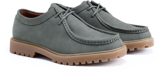Paar grijze suède loafers met vetersluiting en dikke bruine zolen.