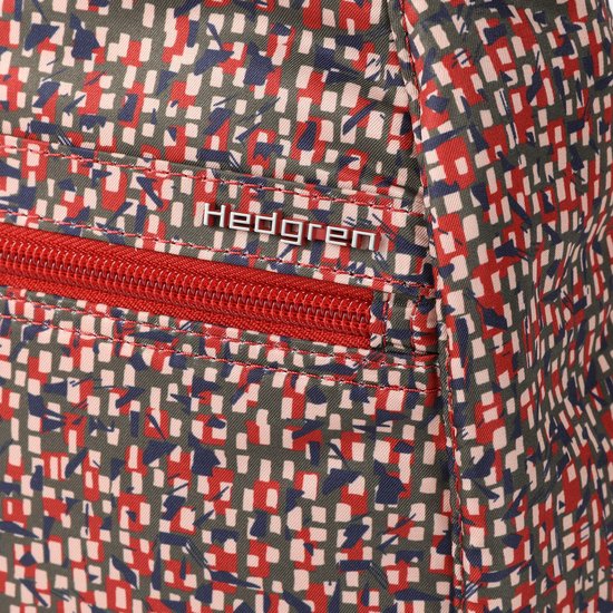 Rits met Hedgren-logo op een rugzak met abstracte print in rood, groen en blauw.