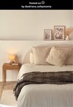 Petite lampe avec base grise et abat-jour orange sur une table de nuit à côté d'un lit.