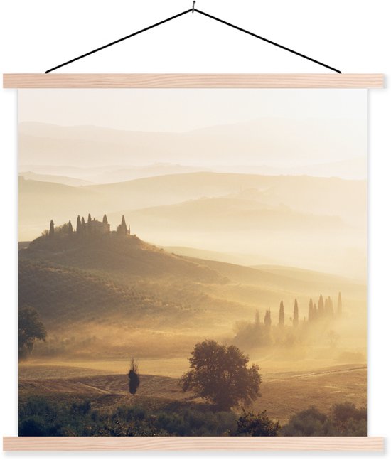 Une affiche textile d'un paysage toscan brumeux au lever du soleil, avec des collines ondulantes et un manoir au sommet. L'affiche a des lattes en bois clairs.
