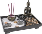 Zen tuin met Boeddhabeeld, wierookhouders met rode wierookstokjes, stenen en een harkje.