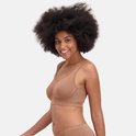 Een vrouw met een grote afro, draagt een bruine naadloze bh zonder beugel. Ze lacht naar de camera.