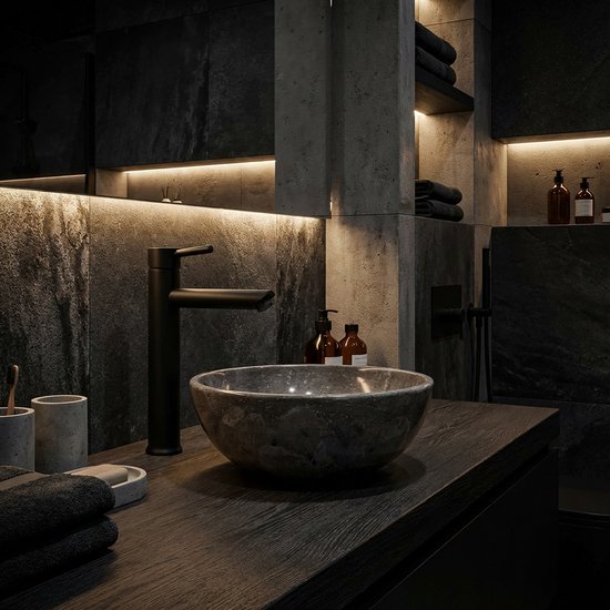 Baignoire en marbre foncé avec robinet noir mat, dans une salle de bain moderne avec éclairage d'ambiance.