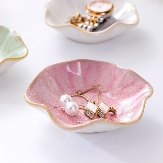 Roze keramische schaal met marmerpatroon, met parelmoer oorbellen en vierkante oorbellen met strass.