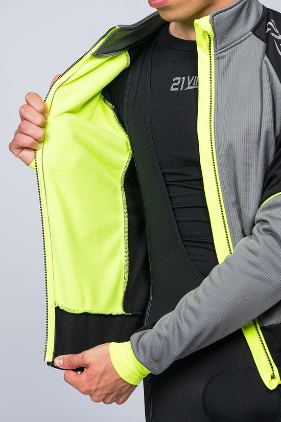 Man opent een zwart fietsjack met fluo-gele voering en accenten. Onder de jas draagt hij een zwart shirt.