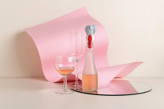 Grijze olifant wijnstopper op een fles, met roze papier en een spiegel.