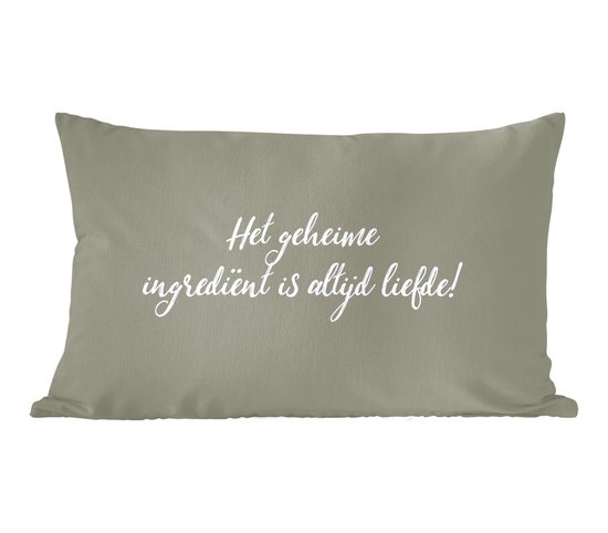 Coussin décoratif vert pâle avec le texte blanc : 'Le secret ingrédient est toujours l'amour !'