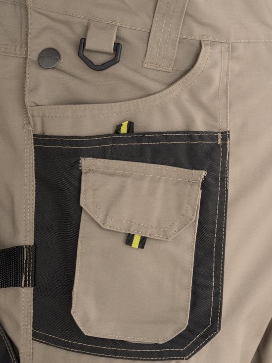 Salopette beige avec bouton STØRVIK, boucle et une poche noire avec boucle jaune et noire.