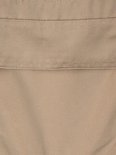Détail de tissu beige d'une salopette, avec des coutures.